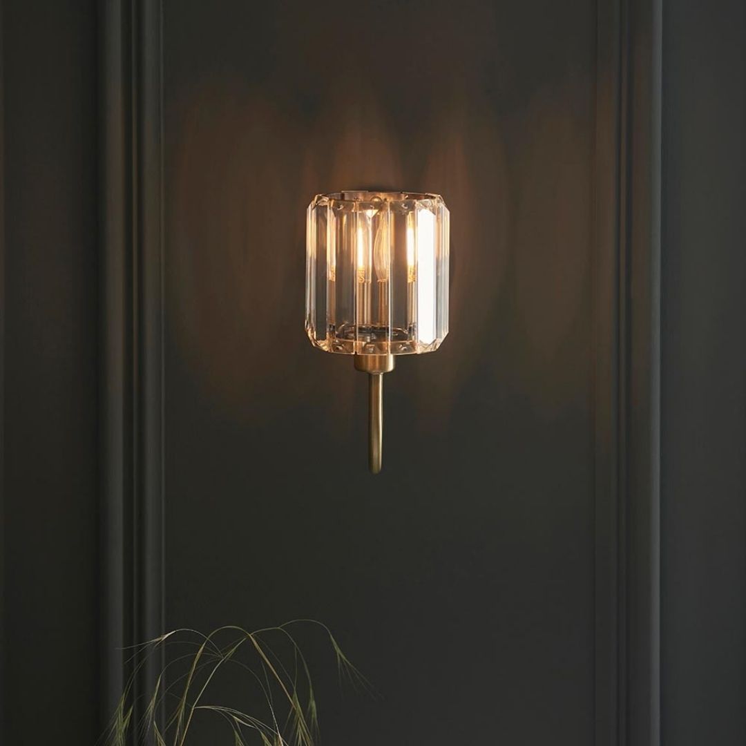 Luz de pared con brazo curvo, pantalla de vidrio facetado y acabado de latón antiguo