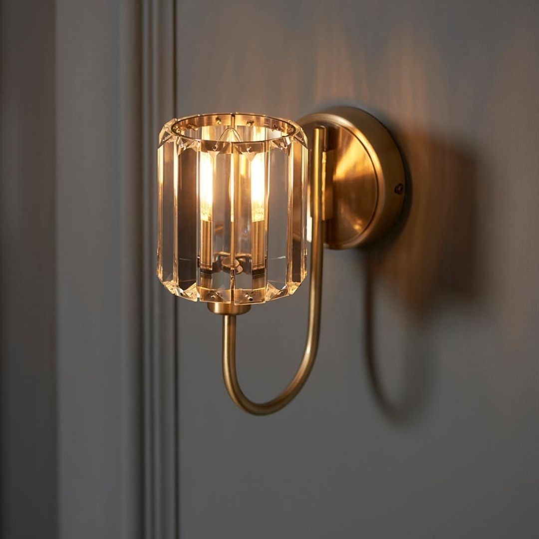 Luz de pared con brazo curvo, pantalla de vidrio facetado y acabado de latón antiguo