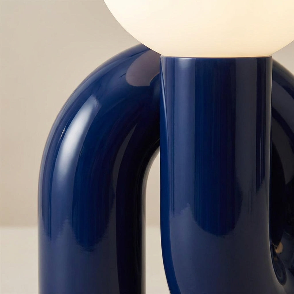 Lámpara de mesa escultural con base de resina y globo de vidrio esmerilado