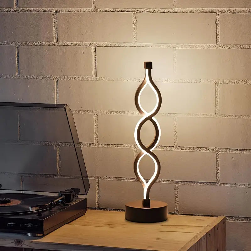 Lámpara de mesa compacta con silueta de espiral escultural y luz cálida