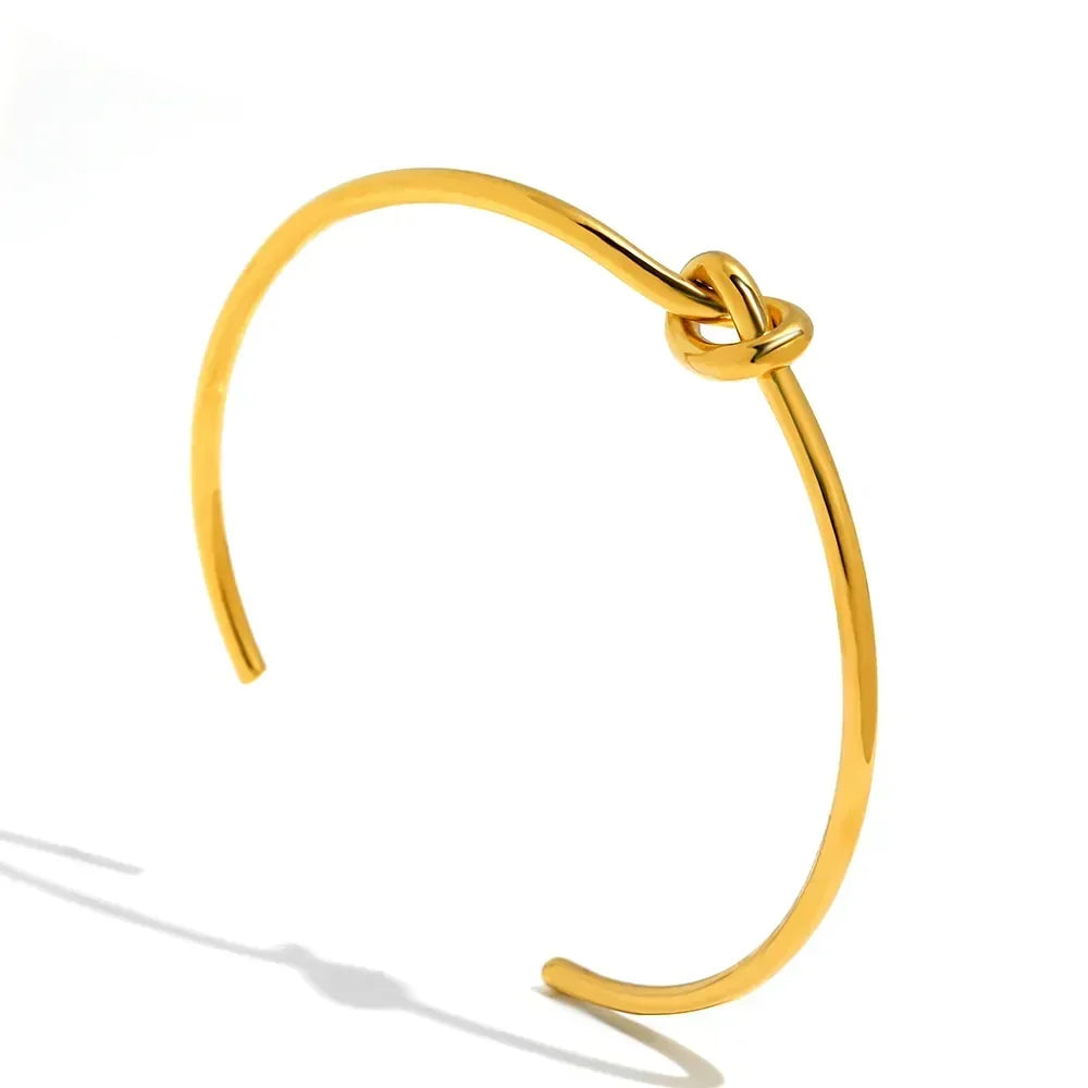 Brazalete de puño abierto chapado en oro con nudo retorcido