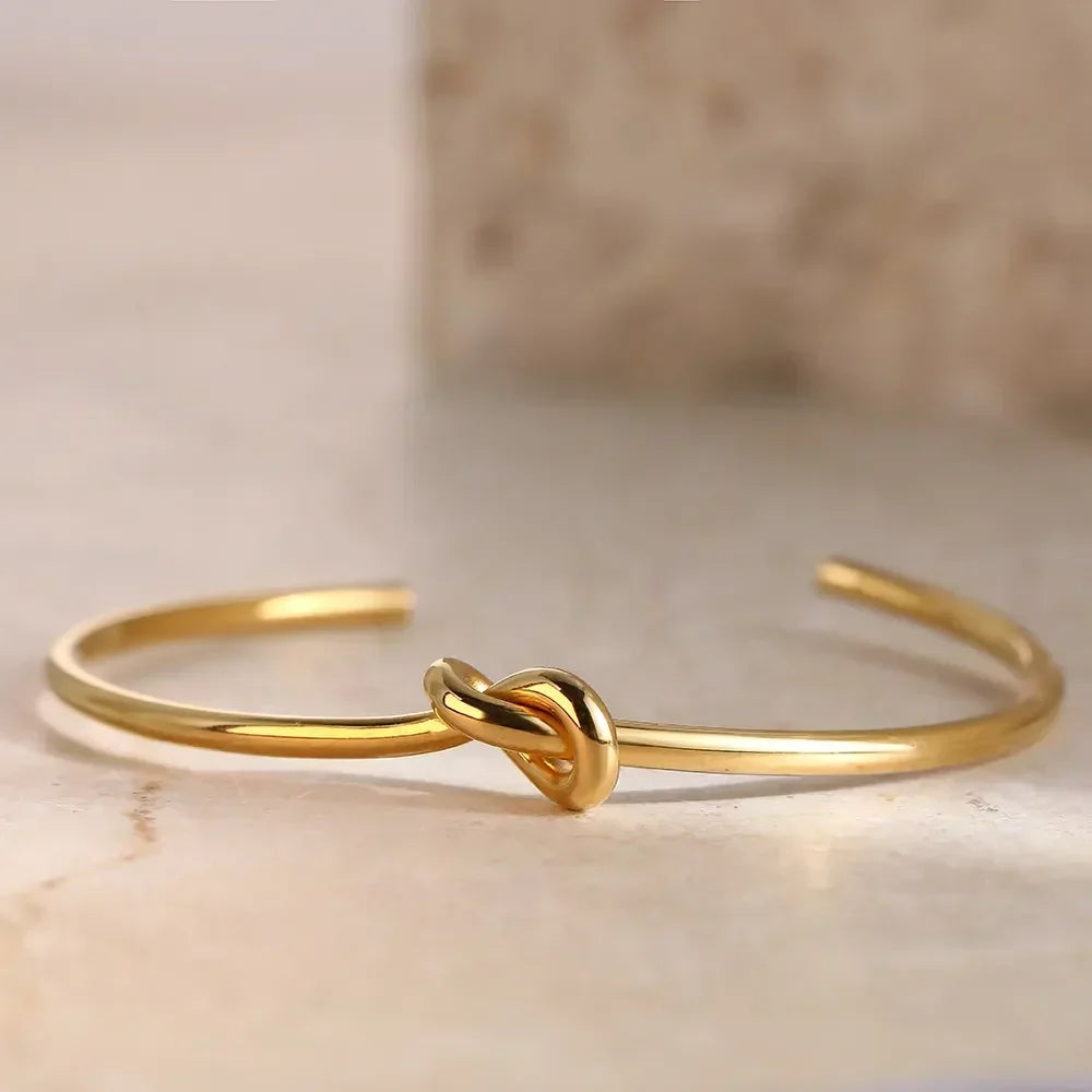 Brazalete de puño abierto chapado en oro con nudo retorcido