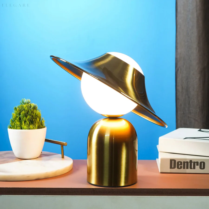 Lámpara de mesa de metal dorado con cabezal inclinado y luz cálida