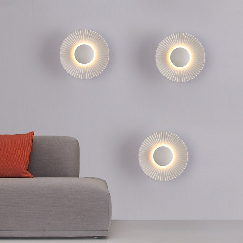 Aplique de pared moderno escultórico con rayos metálicos texturizados en forma de sol
