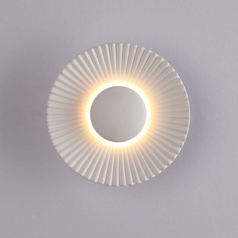Aplique de pared moderno escultórico con rayos metálicos texturizados en forma de sol