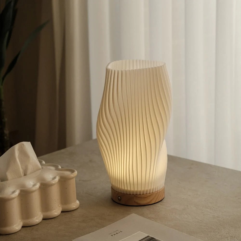 Lámpara de mesa regulable con pantalla esculpida en forma de onda y base de madera