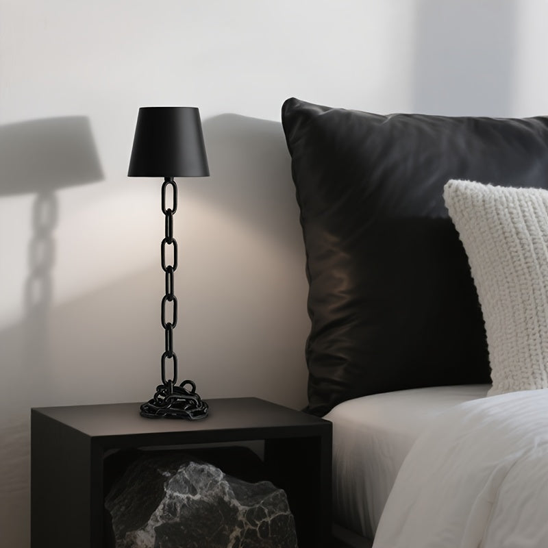 Lámpara de mesa industrial recargable con diseño escultórico de eslabones de cadena y control táctil
