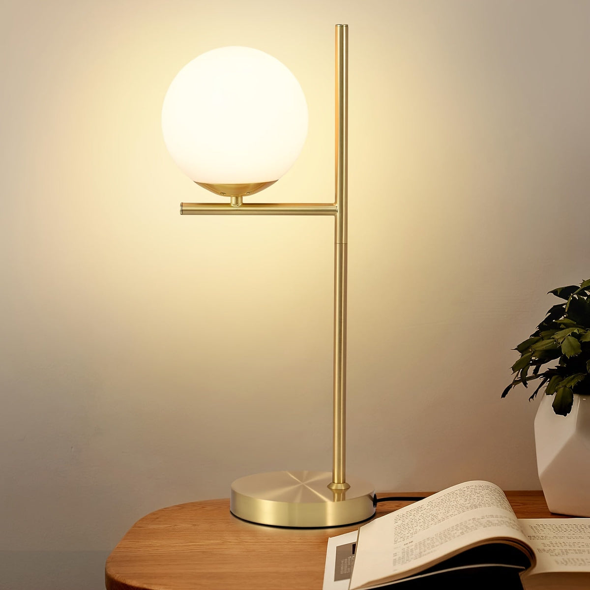 Lámpara de mesa industrial elegante con estructura de latón y esfera de vidrio esmerilado