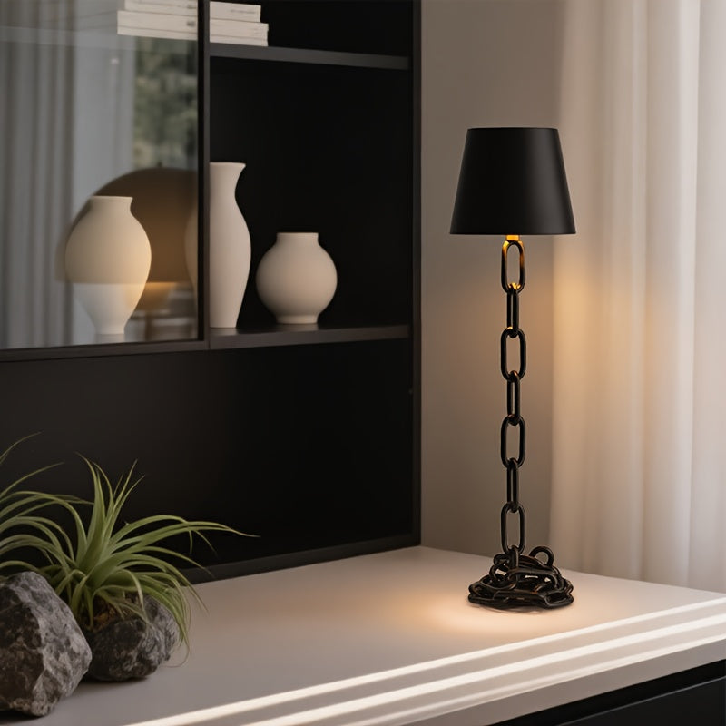 Lámpara de mesa industrial recargable con diseño escultórico de eslabones de cadena y control táctil