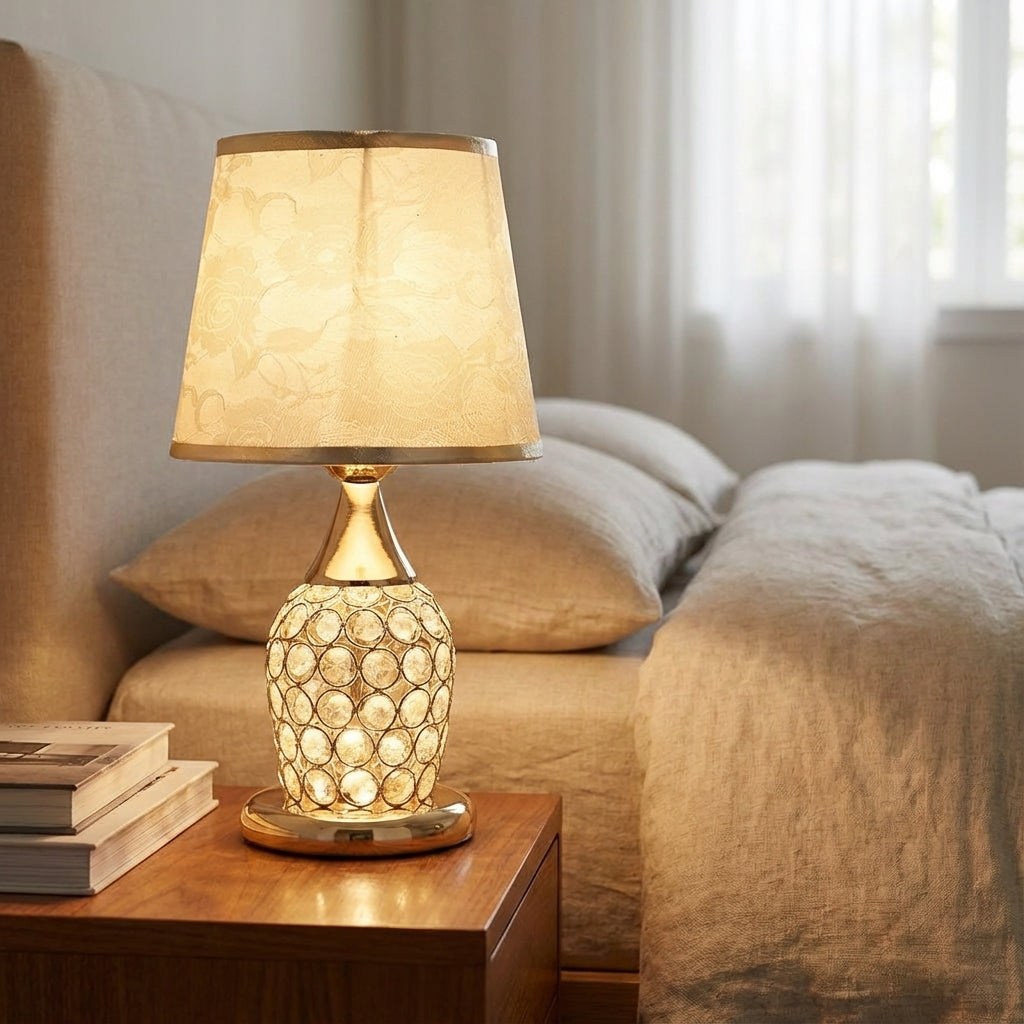 Lámpara de mesa con detalle de cristal brillante, silueta estilizada y pantalla de tambor cónica