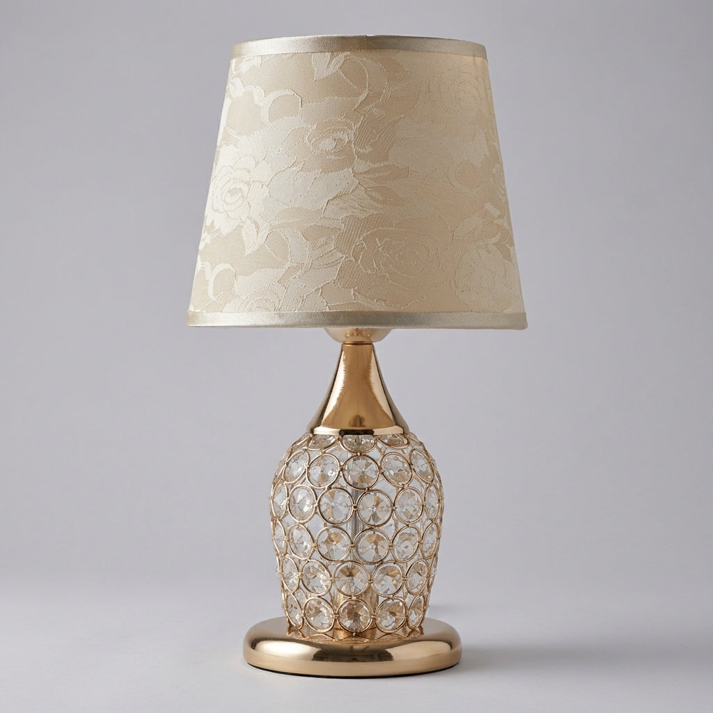 Lámpara de mesa con detalle de cristal brillante, silueta estilizada y pantalla de tambor cónica