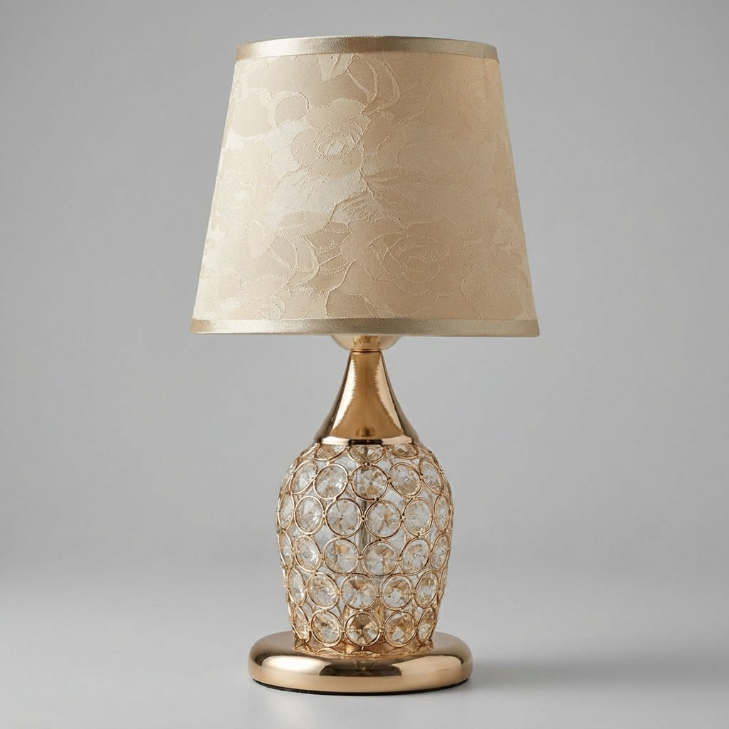 Lámpara de mesa con detalle de cristal brillante, silueta estilizada y pantalla de tambor cónica