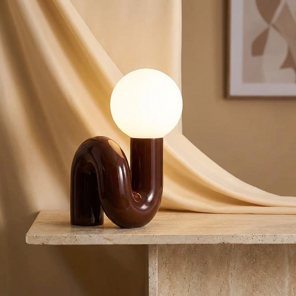 Lámpara de mesa escultural con base de resina y globo de vidrio esmerilado