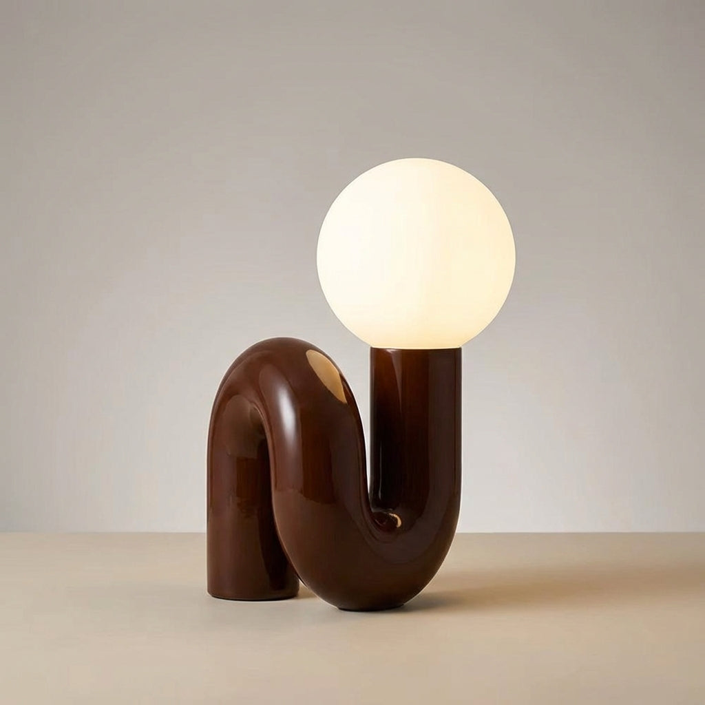Lámpara de mesa escultural con base de resina y globo de vidrio esmerilado