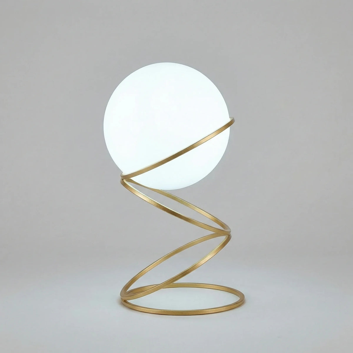 Lámpara de mesa escultural con base metálica en espiral y esfera de acrílico redonda