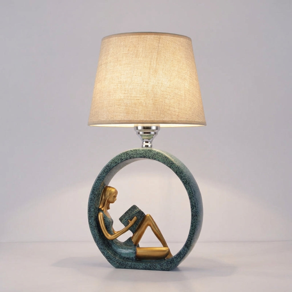 Lámpara de mesa escultórica con figurilla de niña leyendo y base de resina