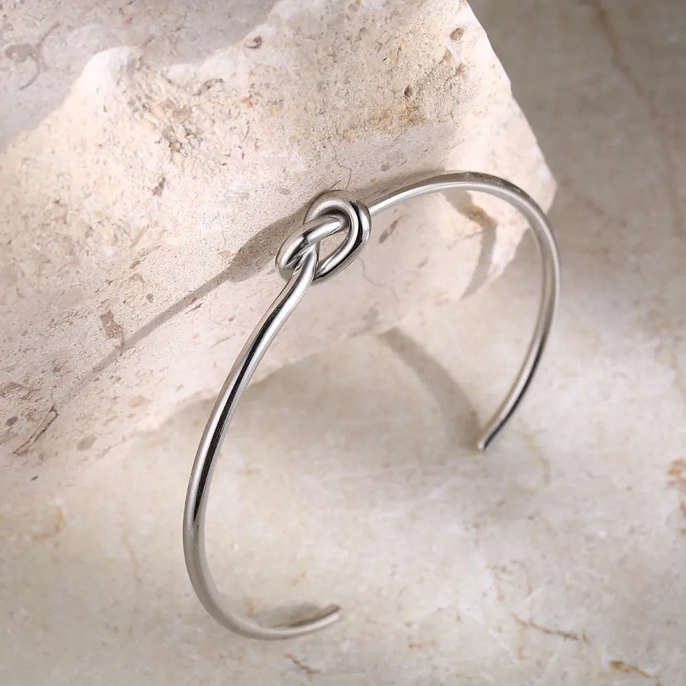 Brazalete de puño abierto chapado en oro con nudo retorcido