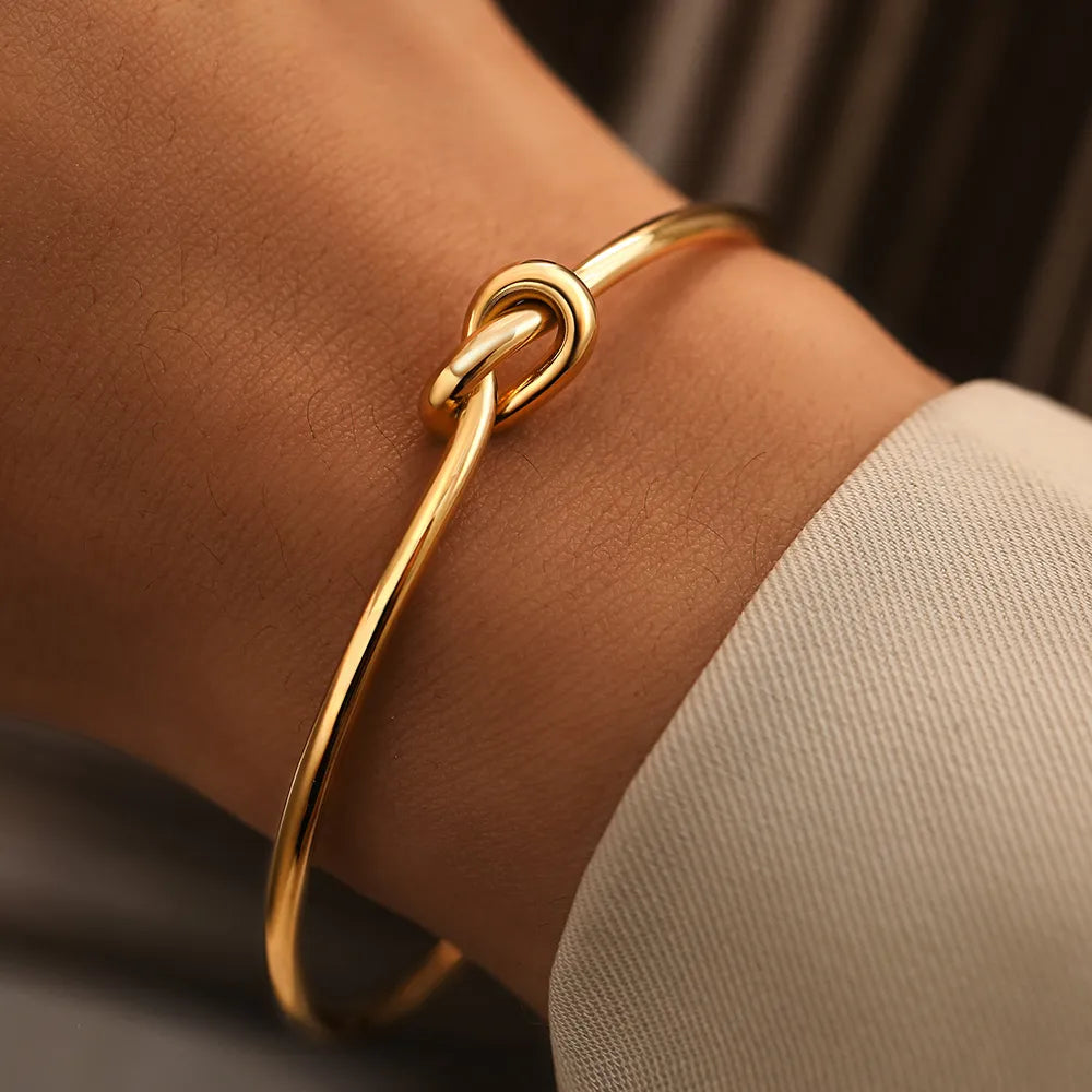 Brazalete de puño abierto chapado en oro con nudo retorcido