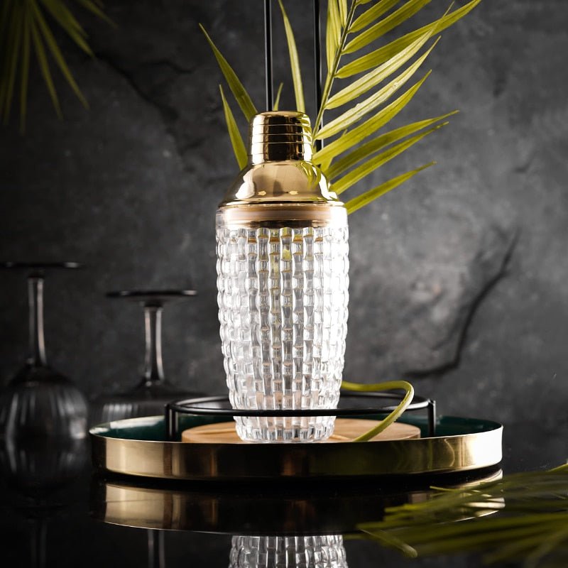Coctelera de vidrio transparente y acero inoxidable con detalles dorados
