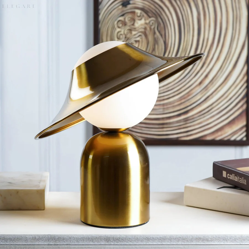 Lámpara de mesa de metal dorado con cabezal inclinado y luz cálida